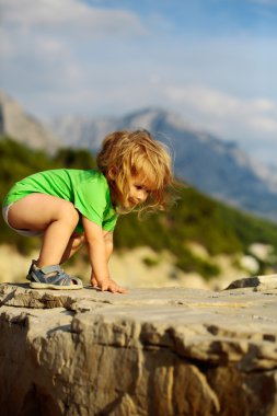 Erkek bebek kayaların üzerinde çalış