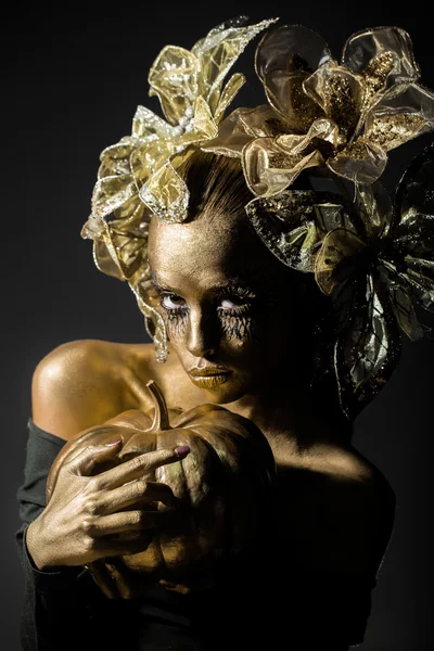 Золотая женщина с тыквой на Хэллоуин — стоковое фото