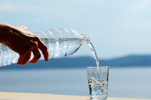 Mano femminile versa acqua — Foto Stock