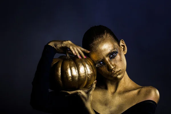 Goldene Frau mit Halloween-Kürbis — Stockfoto