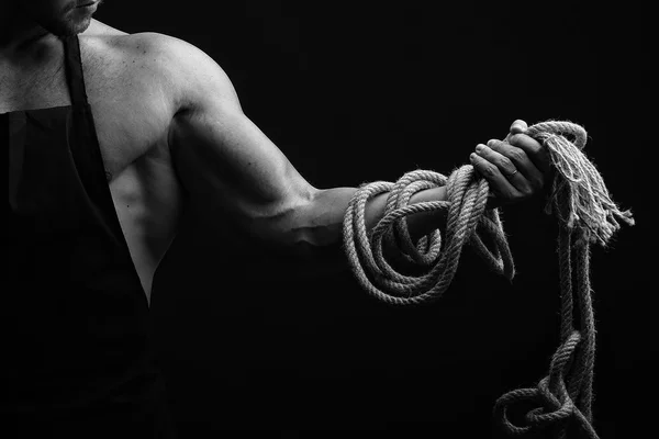 Мускулистый человек в фартуке с веревкой — стоковое фото
