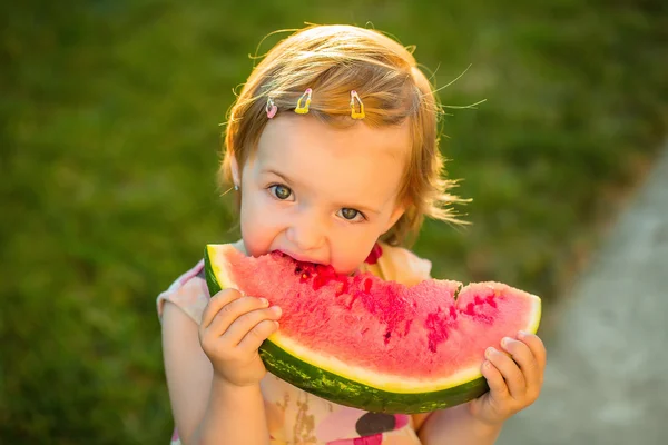 Flicka äter röd vattenmelon utomhus — Stockfoto