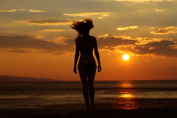 Woman silhouette in sunset beach — Stock Photo, Image