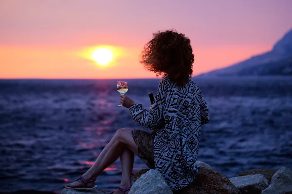 woman with wine on evening beach