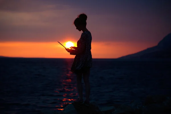 Silhueta feminina com laptop no pôr do sol — Fotografia de Stock