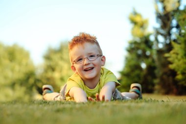 Çimenlerin üzerinde bardaklarda Kızıl saçlı erkek mutlu bebek