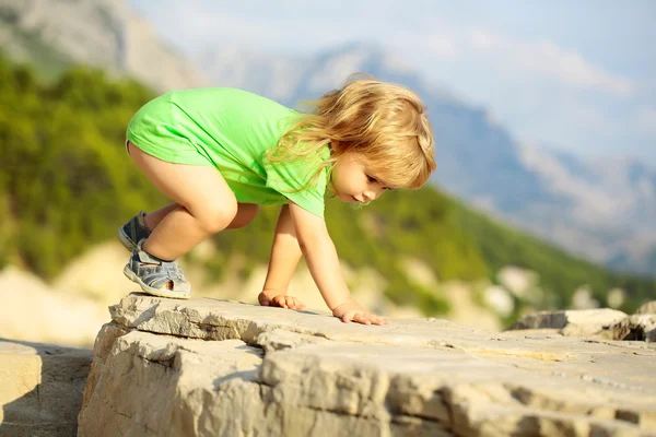 Bambino ragazzo gioca sulle rocce — Foto Stock