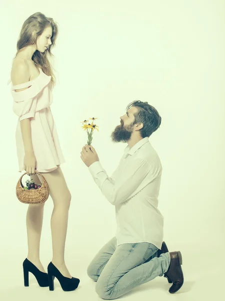Unga par gör förslaget med blommor som isolerade — Stockfoto