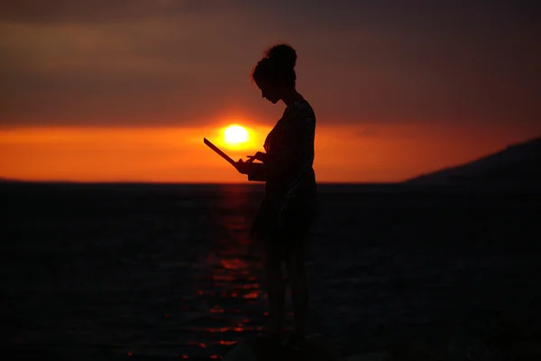 Female silhouette with laptop on sunset — Stock Photo, Image