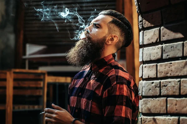 Взрослый мужчина выдыхает сигаретный дым — стоковое фото