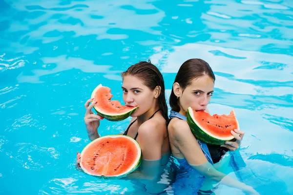 Mujeres con sandía en la piscina — Foto de Stock