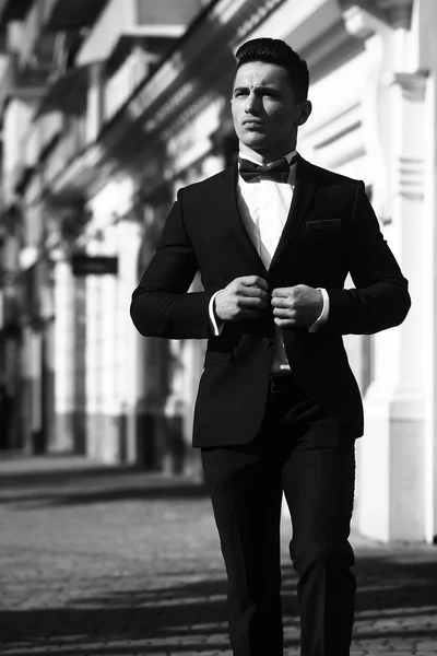 Elegant man unbuttons suit coat