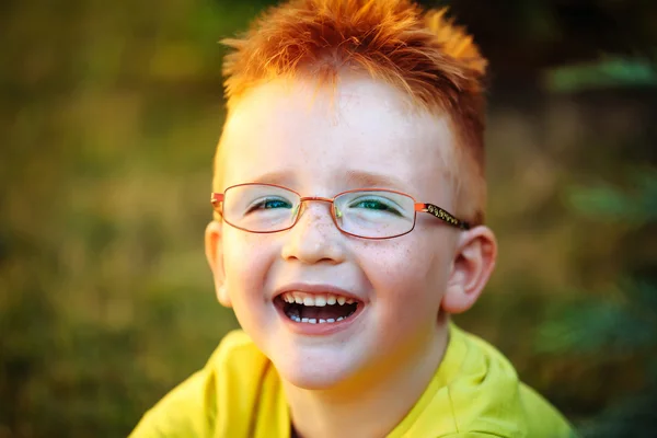Ευτυχισμένο μωρό αγόρι με κόκκινα μαλλιά σε ποτήρια — Φωτογραφία Αρχείου