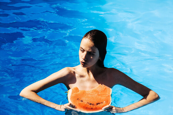 woman with watermelon in swimming pool