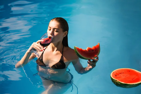 Mujer con sandía y vino en la piscina — Foto de Stock