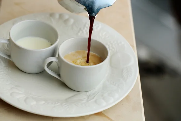 Pot gieten koffie in melk — Stockfoto