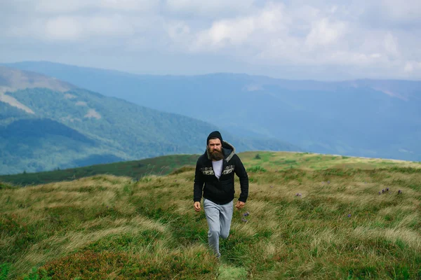 Hombre camina en la cima de la montaña — Foto de Stock