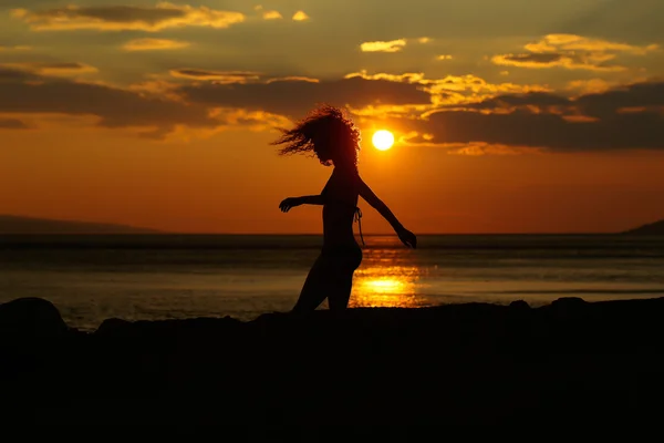 Silhouette femme au coucher du soleil plage — Photo