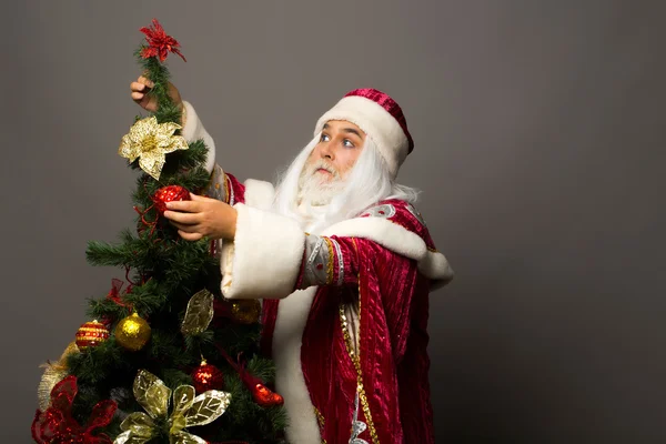Weihnachtsmann schmückt Weihnachtsbaum — Stockfoto
