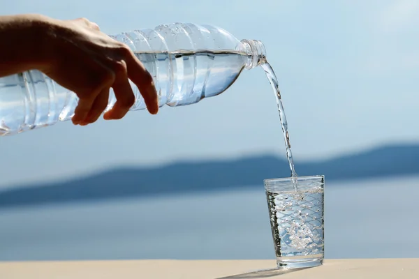 Mano femminile versa acqua — Foto Stock