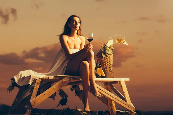 Mujer bonita con vino sobre el cielo —  Fotos de Stock