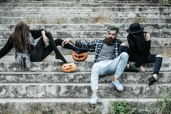 Halloween man en meisjes met pompoen — Stockfoto