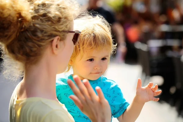 Mother holds son in street — Stock Photo, Image