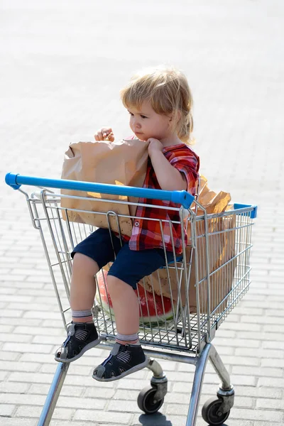 Rapaz bonito no carrinho de compras — Fotografia de Stock