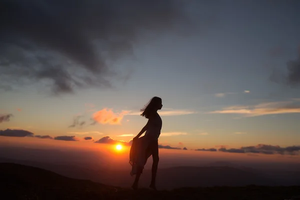 Frau bei Sonnenuntergang oder Sonnenaufgang in den Bergen — Stockfoto