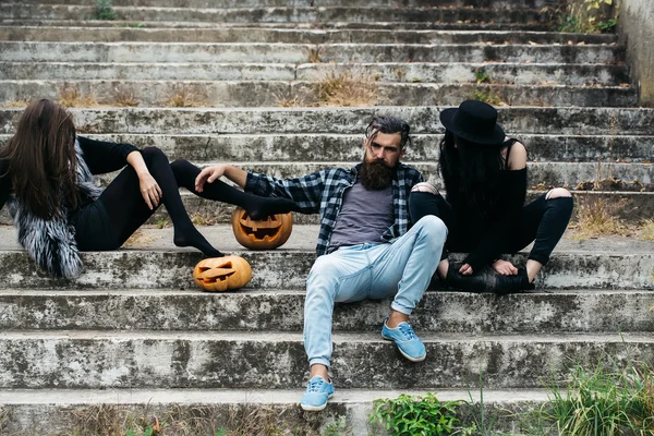 Halloween man en meisjes met pompoen — Stockfoto