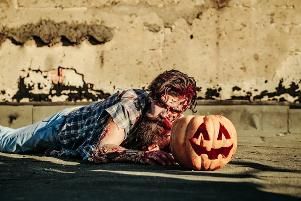 Zombie man crawls for pumpkin — Stock Photo, Image