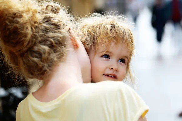 Mother holds son in street — Stock Photo, Image