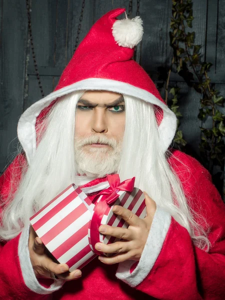 Серьезный рождественский человек с подарком — стоковое фото