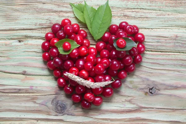 Cuore di ciliegia rossa sorridente su legno — Foto Stock