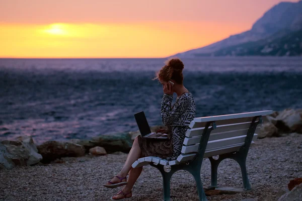 夜のビーチでノート パソコンを持つ女性 — ストック写真