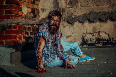 Zombi adam asfalt üzerinde oturur
