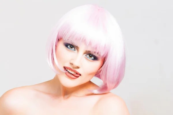 Jonge mooie meisje in roze pruik — Stockfoto