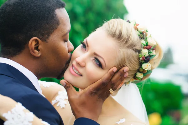 Groom kisses face of bride