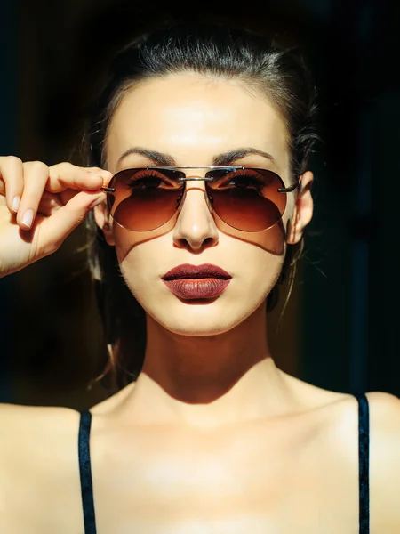 Симпатичная девушка в коричневых солнцезащитных очках — стоковое фото