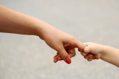 Anneler tutan babys el