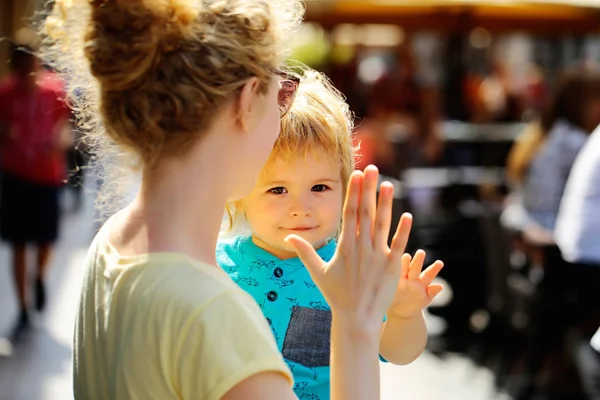 Mother holds son in street — Stock Photo, Image