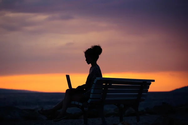 Kvinna med laptop på kvällen beach — Stockfoto