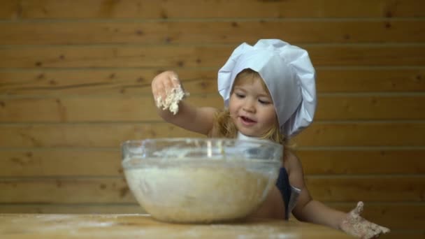 Маленький кухар дитячого майстра, вкритий борошном, готує з мамою — стокове відео