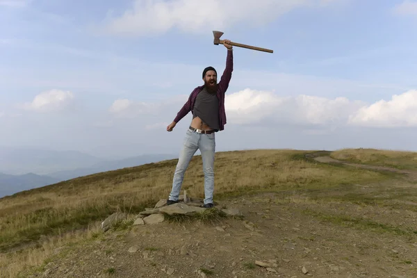 Hombre barbudo con hacha en la montaña — Foto de Stock