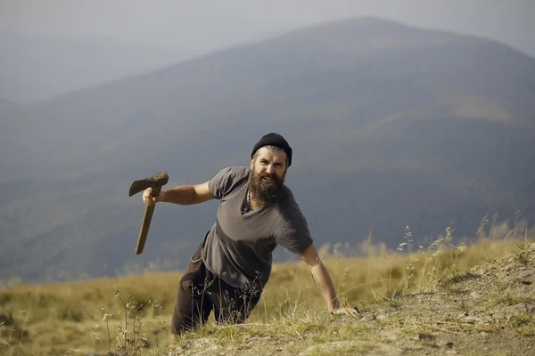 Hombre barbudo con hacha en la montaña — Foto de Stock