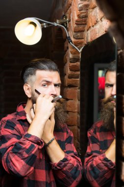 Aynanın yanında jileti olan adam.