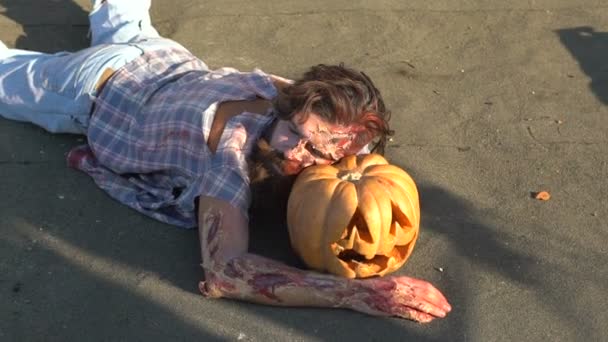 Zombies tumbados en la calle en una calabaza, Halloween se celebra — Vídeos de Stock