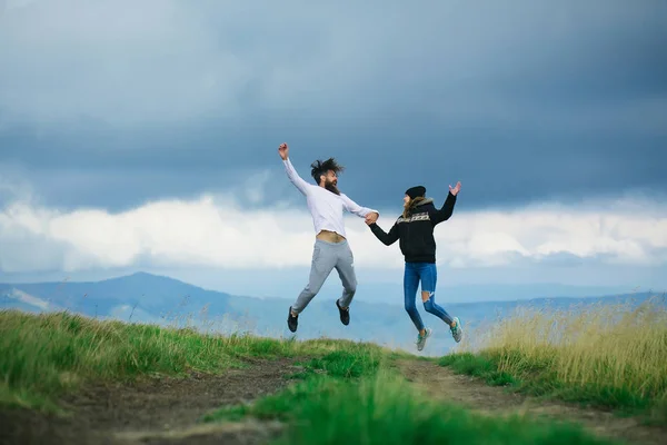 Couple bouncing on gray sky — Stock Photo, Image