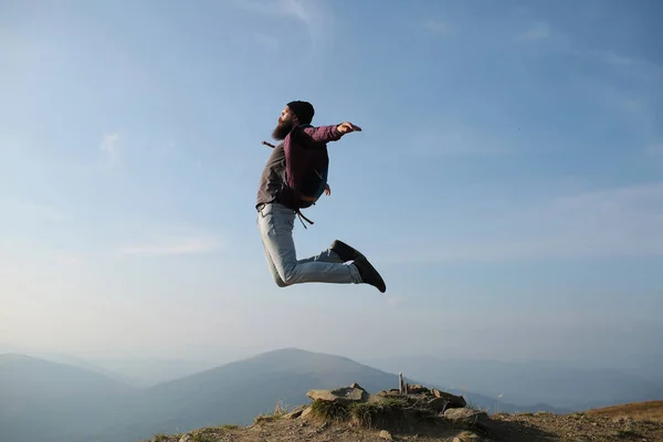 Homem hipster salta com mochila — Fotografia de Stock