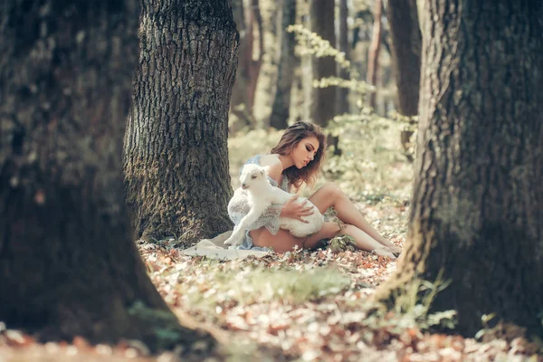 Молодая женщина с козой в лесу — стоковое фото